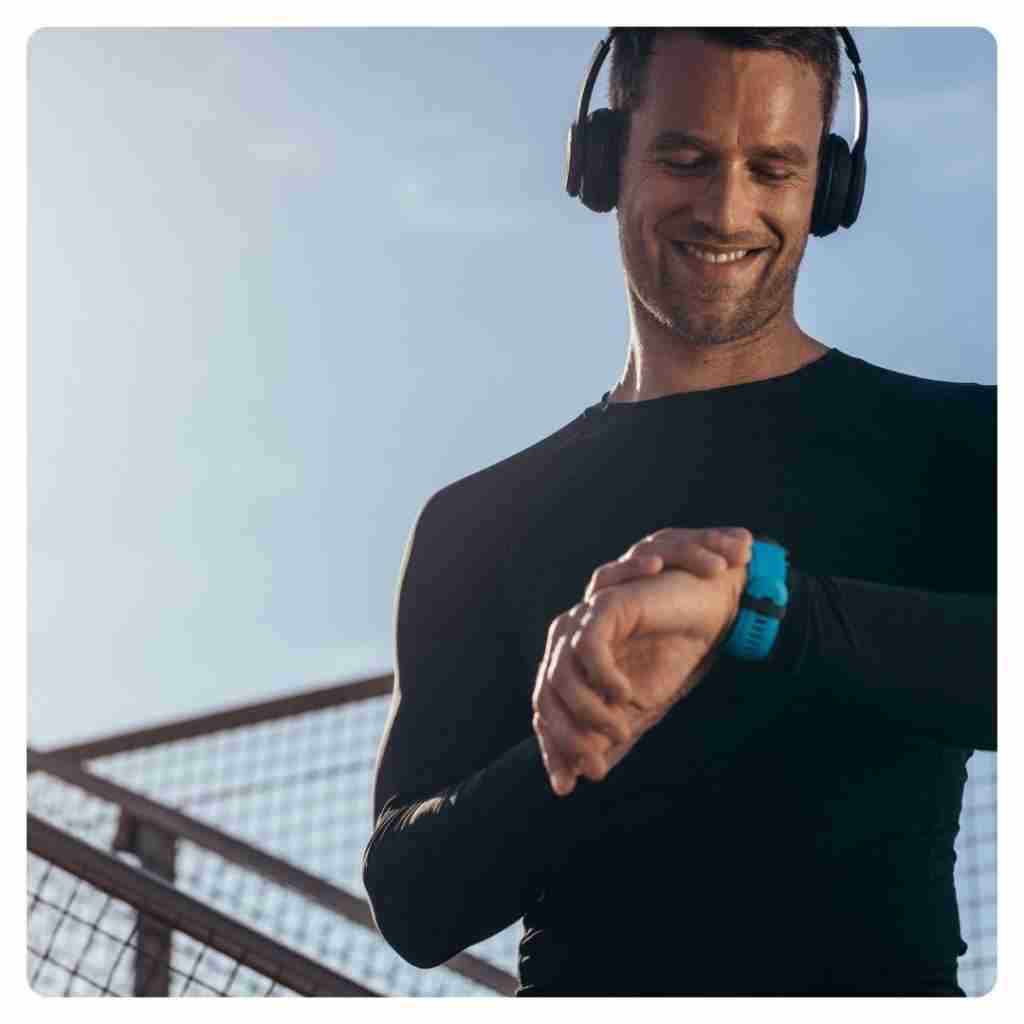 Benefits of Chiropractic Adjustments - male finishing up a run looking at his watch with a smile on his face