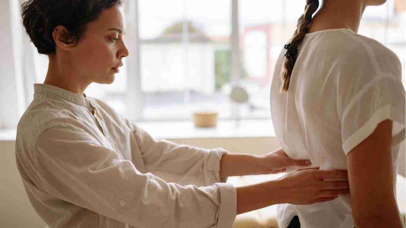 chiropractor assessing the spinal alignment of a female patients back